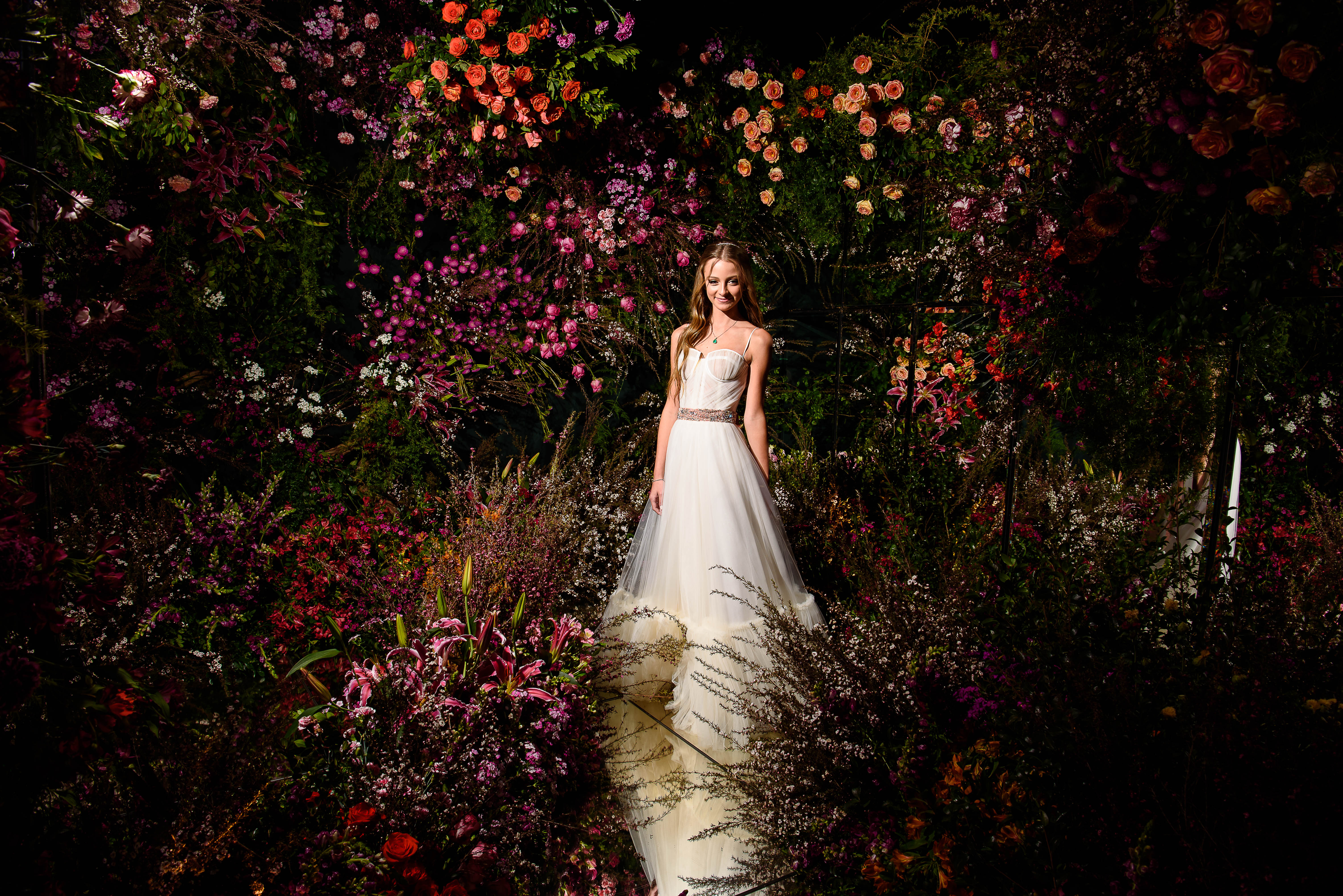 Debutante posando para foto em sua parede de flores
