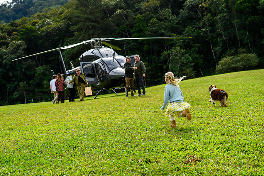 Vicky correndo receber os convidados que chegaram de helicóptero.